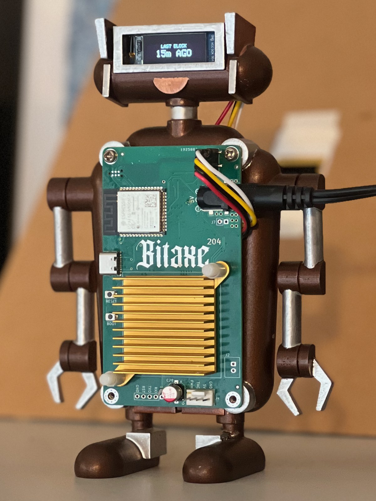 Current Bitaxe Robot Bitcoin Display with a green Bitaxe 204 board, gold heatsink, and last-block screen
